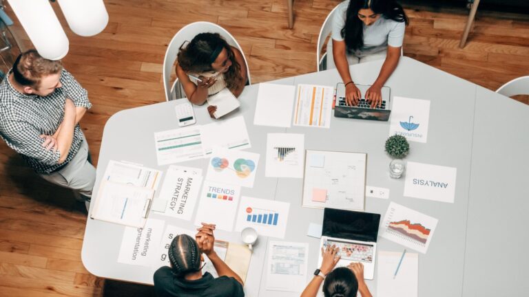 A diverse team working on marketing strategies with charts and laptops in an office setting